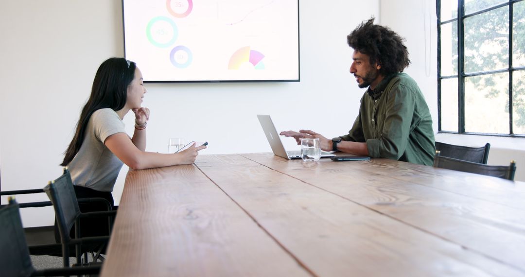 Professionals Discussing Presentations in Modern Office