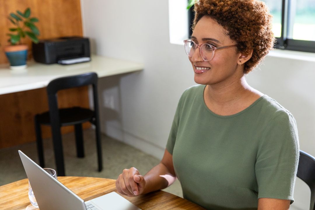 Smiling Professional Working on Laptop in Home Office