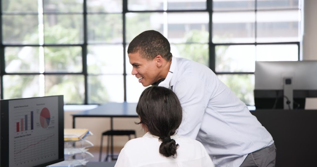 Colleagues Collaborating Over Financial Report in Bright Office
