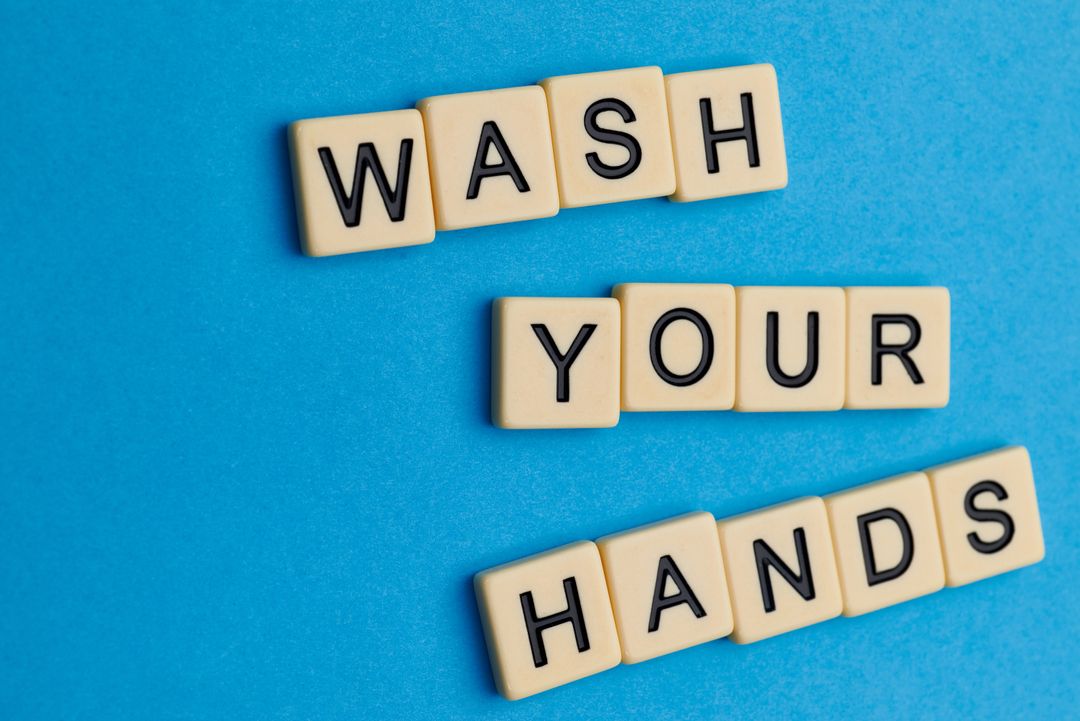 Scrabble Letters Spelling Wash Your Hands on Blue Background