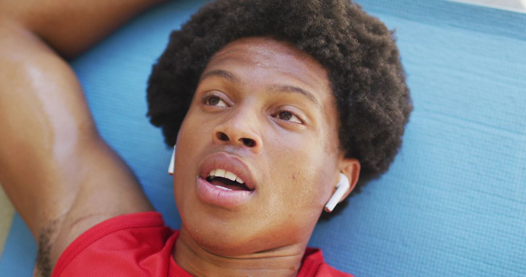 Exhausted Young Man Resting After Workout on Yoga Mat