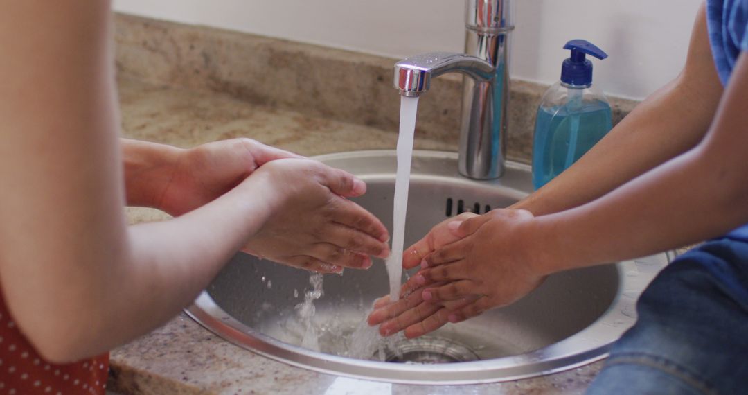 Mother and Child Washing Hands Together at Kitchen Sink - Free Images, Stock Photos and Pictures on Pikwizard.com