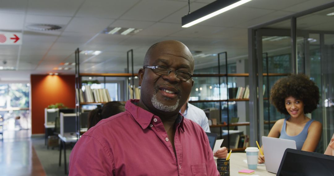 Confident Businessman Leading Diverse Team in Modern Office