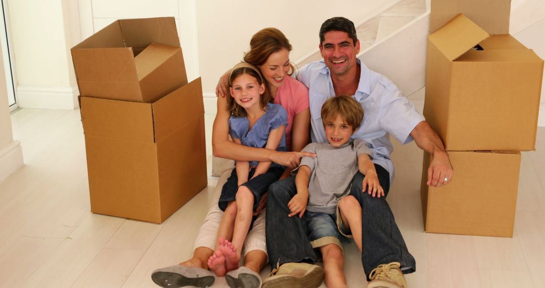 Happy Family Sitting in New Home with Moving Boxes - Free Images, Stock Photos and Pictures on Pikwizard.com