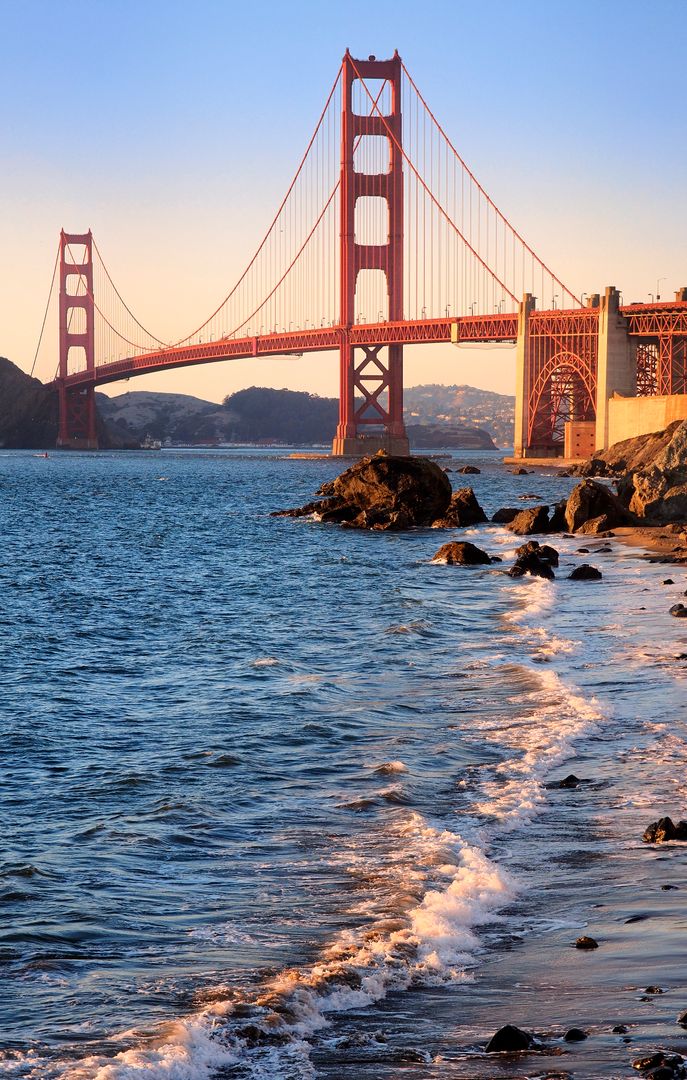 Golden Gate Bridge at sunset with rocky beach foreground - Free Images, Stock Photos and Pictures on Pikwizard.com