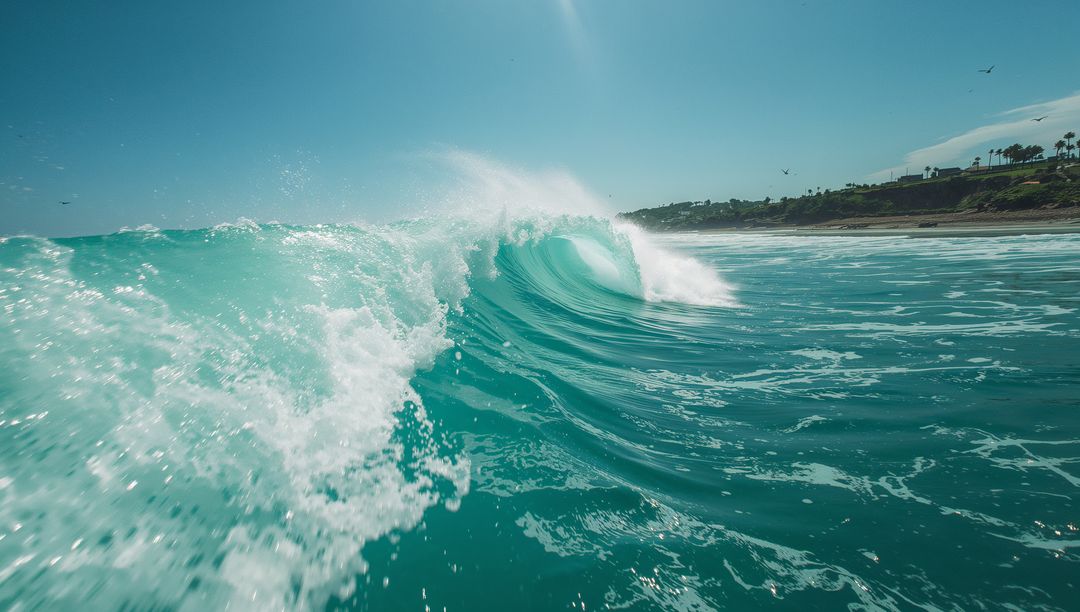 Dynamic Ocean Wave Crashing on Sunlit Beachfront with Palm Trees