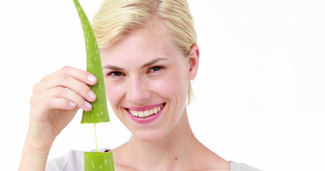 Smiling Woman Cutting Aloe Vera Leaf for Skincare and Wellness - Free Images, Stock Photos and Pictures on Pikwizard.com