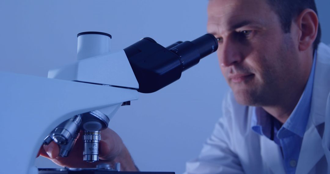 Scientist Analyzing Samples through Microscope in Laboratory