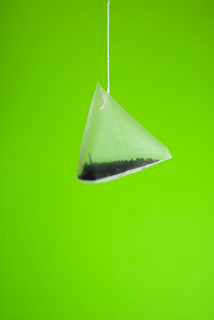 Pyramid Tea Bag Hanging Against Green Background - Free Images, Stock Photos and Pictures on Pikwizard.com