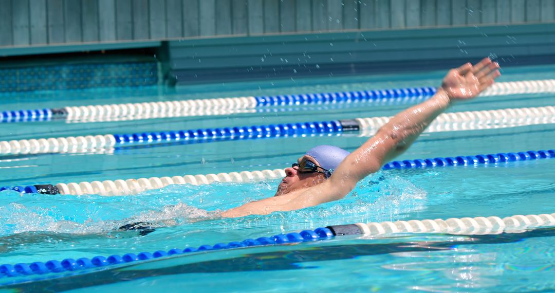 Professional Swimmer Performing Backstroke in Olympic Pool - Free Images, Stock Photos and Pictures on Pikwizard.com