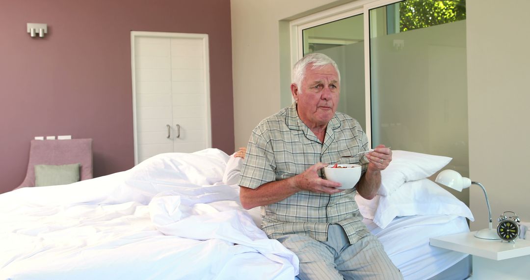 Elderly Man Having Breakfast in Bed in Modern Bedroom - Free Images, Stock Photos and Pictures on Pikwizard.com