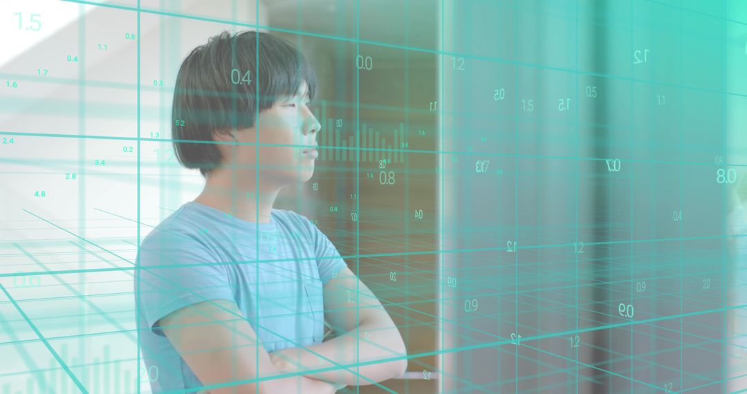 Standing Asian man crossing arms, facing right, observing teal data overlay in modern office