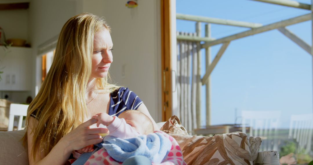 Mother with Newborn Relaxing by Sunny Window - Free Images, Stock Photos and Pictures on Pikwizard.com