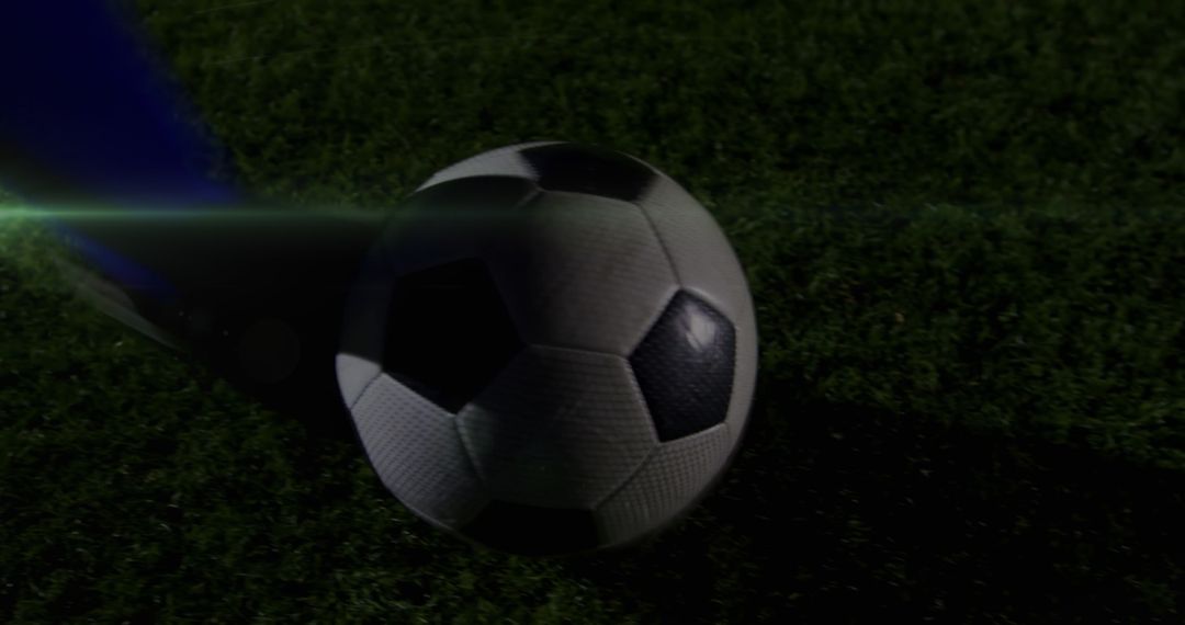 Football Player Kicking Ball with Light Trails at night