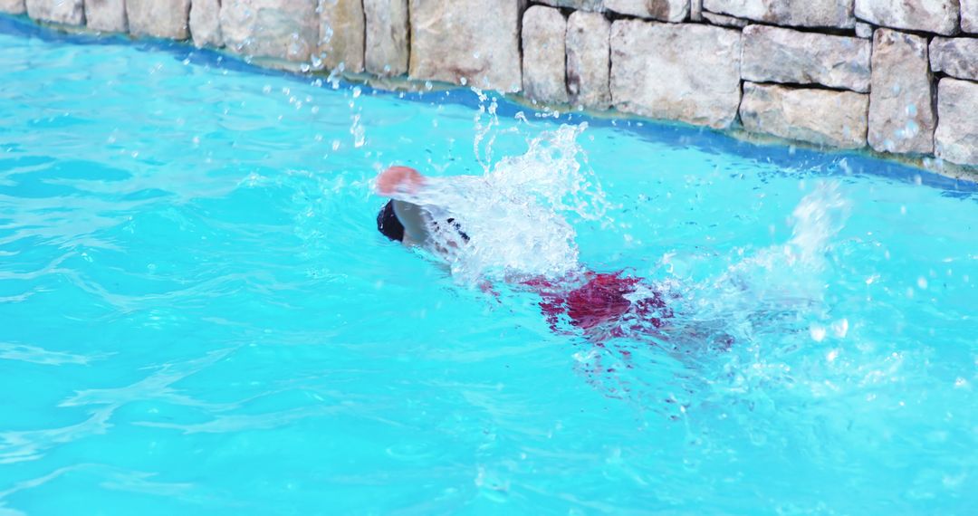 Person Swimming Freestyle in Clear Blue Pool with Stone Wall - Free Images, Stock Photos and Pictures on Pikwizard.com