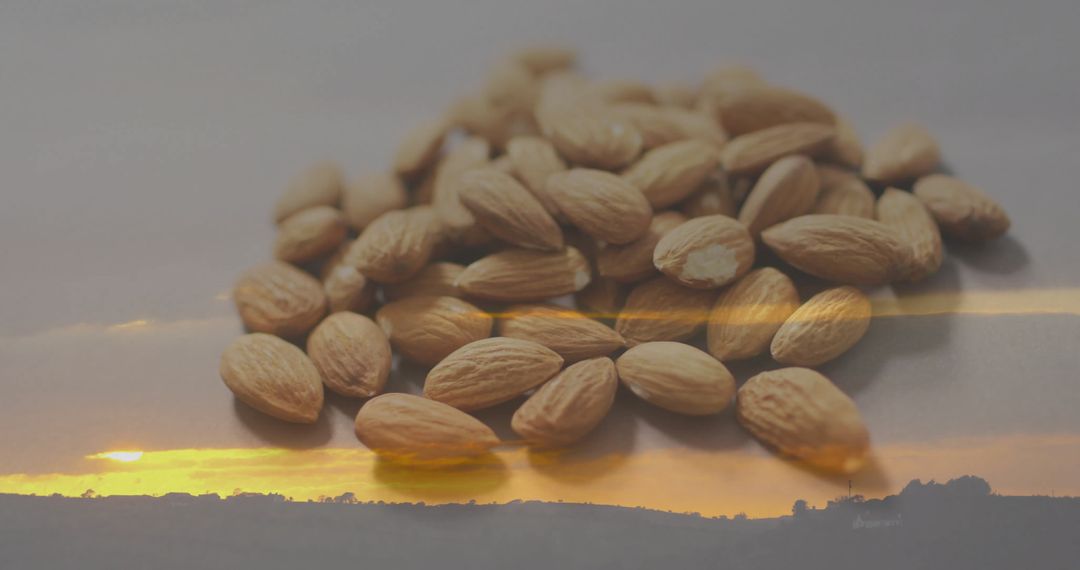 Whole Almonds on Reflective Surface with Sunset in Background