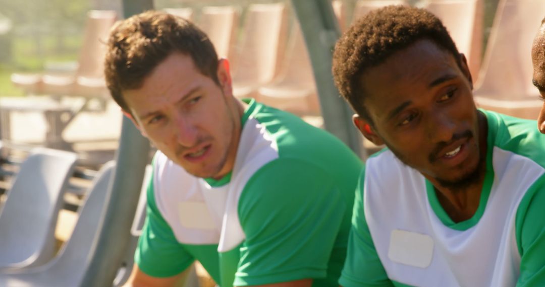 Diverse Male Football Players Conversing on Sidelines