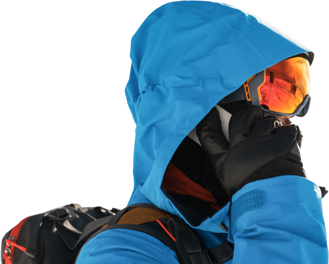 Skier in Blue Jacket Using Phone with Orange Goggles Transparent