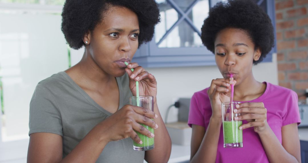 Mother and Daughter Drinking Healthy Green Smoothies in Kitchen - Free Images, Stock Photos and Pictures on Pikwizard.com