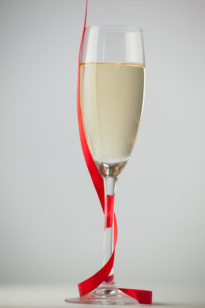 Close-up of champagne flute with a red ribbon - Free Images, Stock Photos and Pictures on Pikwizard.com