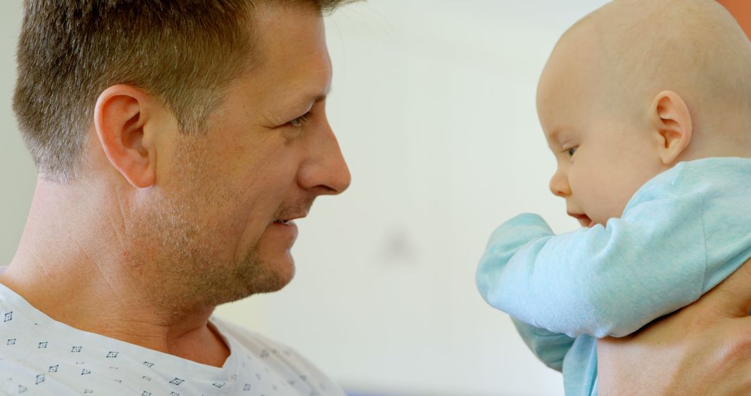 Loving Father Holding Baby in Bright Room - Free Images, Stock Photos and Pictures on Pikwizard.com