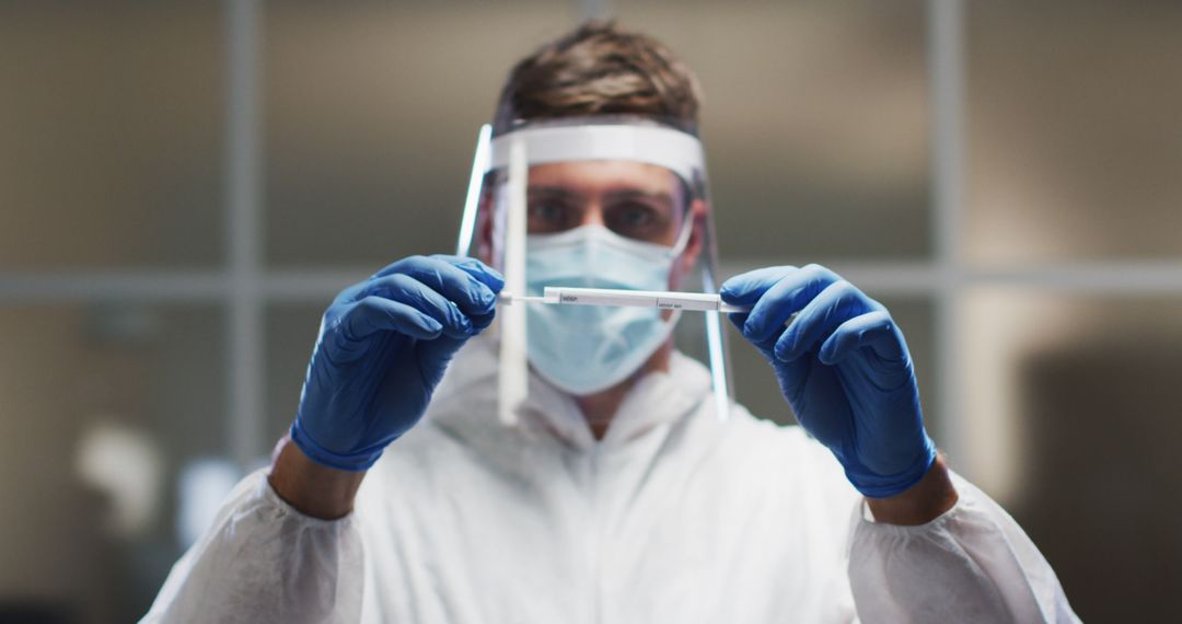 A medical worker in protective gear examines a DNA swab amid COVID-19 research efforts. - Free Images, Stock Photos and Pictures on Pikwizard.com