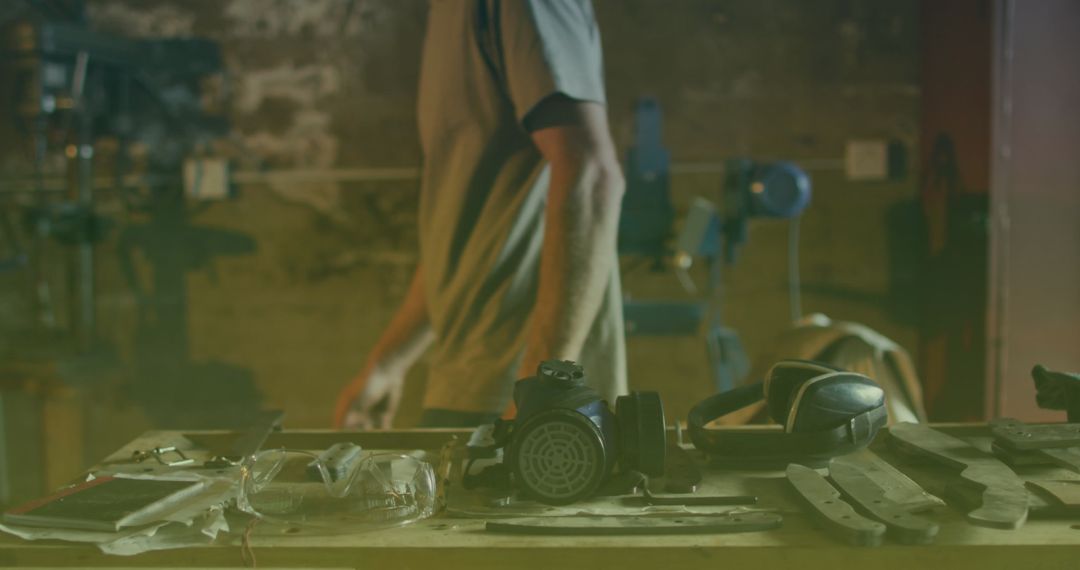 Workshop Table with Tools and Worker in Background
