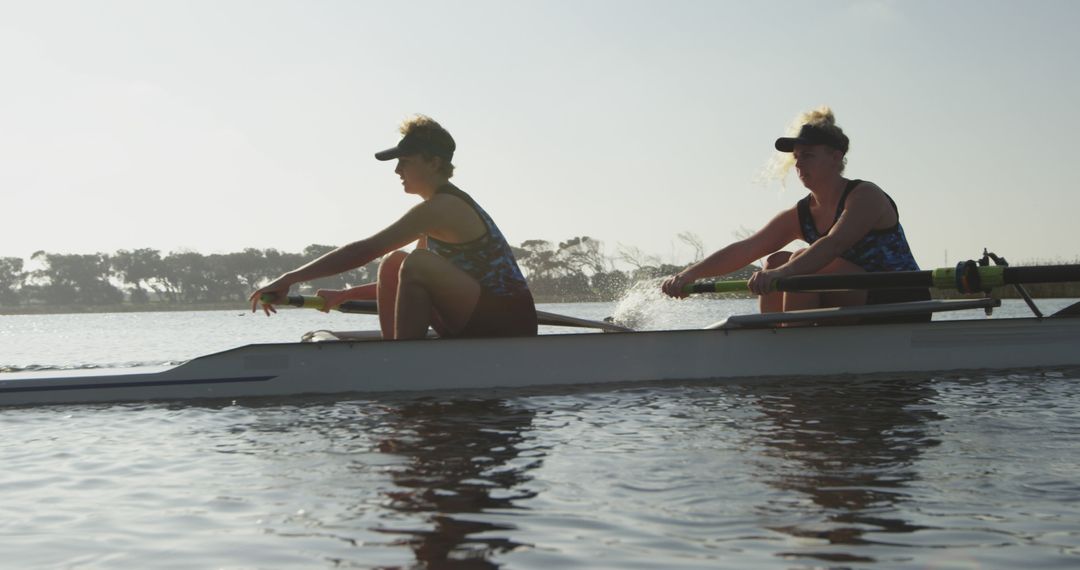 Female Rowers Synchronizing Teamwork on Tranquil River - Free Images, Stock Photos and Pictures on Pikwizard.com