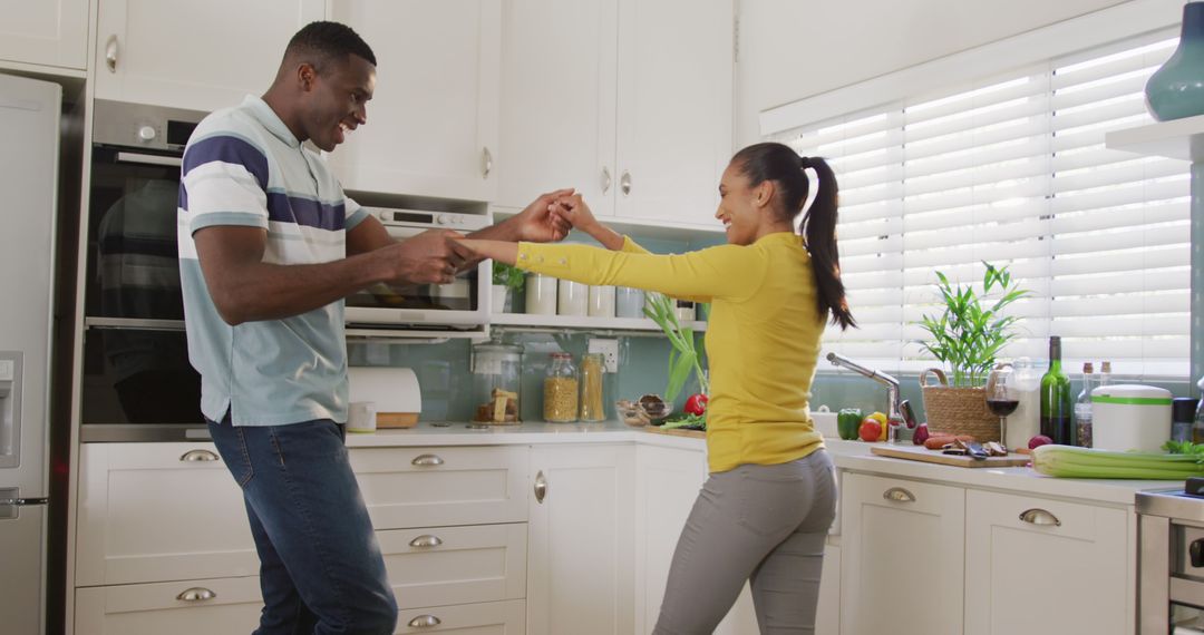 Image of happy diverse couple having fun dancing together in kitchen - Free Images, Stock Photos and Pictures on Pikwizard.com