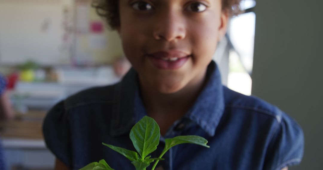 Young Girl Smiling Holding Plant in Classroom for Nature Study - Free Images, Stock Photos and Pictures on Pikwizard.com