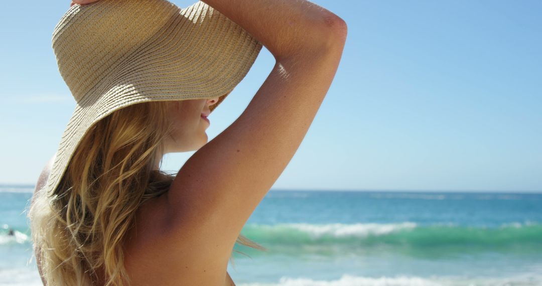 Young Woman Relaxing at Beach with Straw Hat on Sunny Day - Free Images, Stock Photos and Pictures on Pikwizard.com