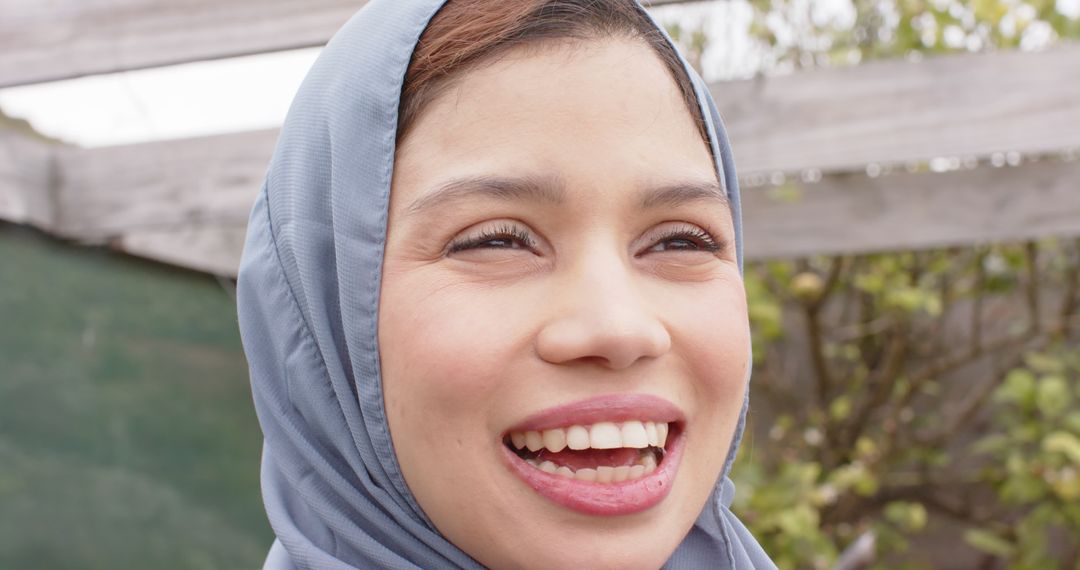 Smiling Woman Wearing Hijab Outdoors on Cloudy Day - Free Images, Stock Photos and Pictures on Pikwizard.com