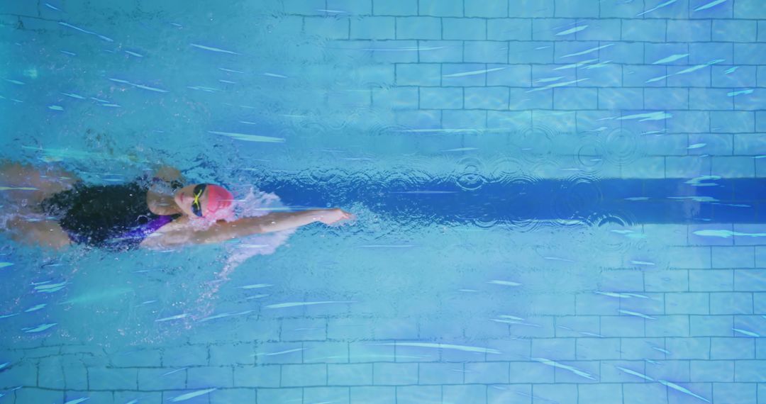 Professional Swimmer Gliding in Pool with Pink Cap and Tinted Goggles