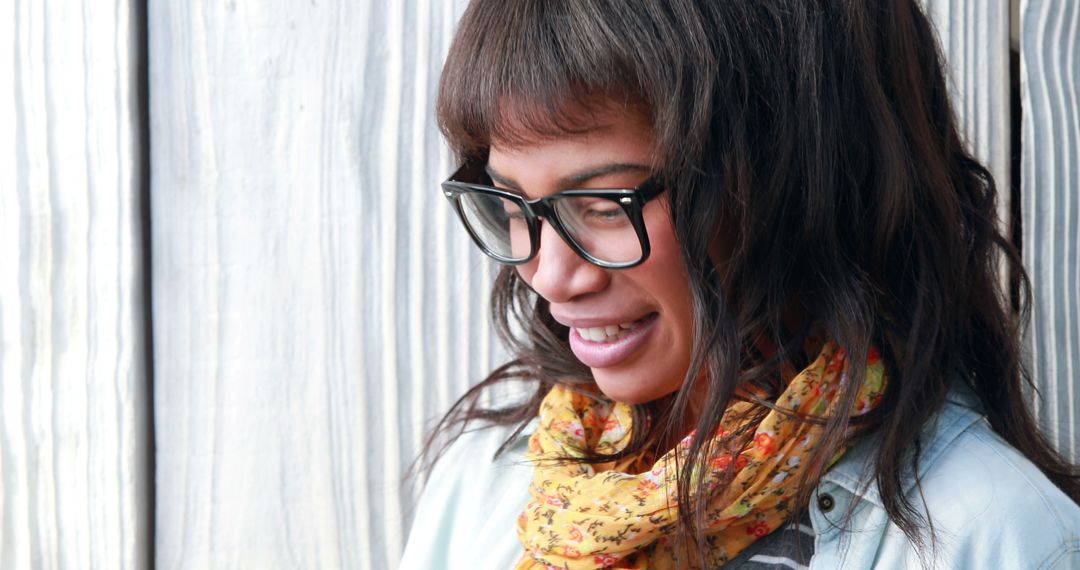 Smiling Young Woman with Glasses and Scarf Against Wooden Background - Free Images, Stock Photos and Pictures on Pikwizard.com