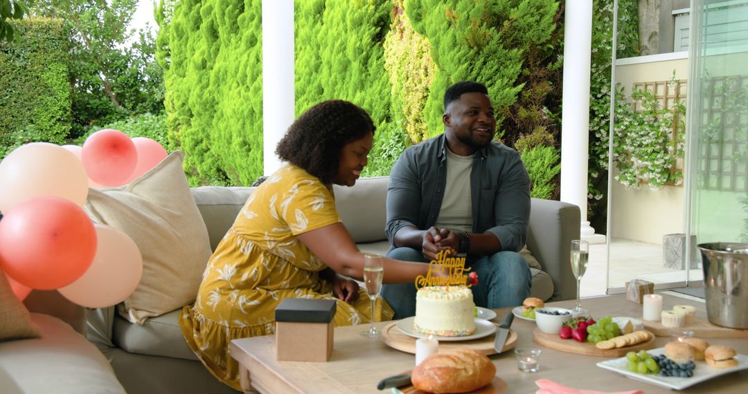 Couple celebrating birthday outdoors with cake and gifts