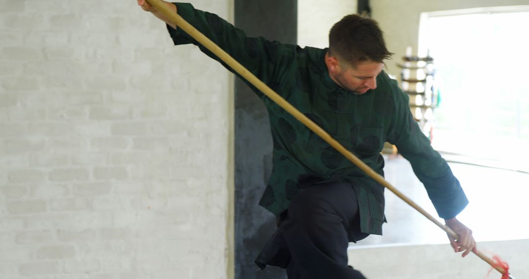 Man Practicing Martial Arts with Staff in Studio - Free Images, Stock Photos and Pictures on Pikwizard.com