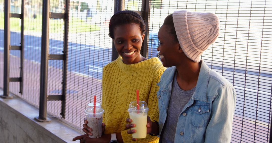 Twin Sisters Enjoying Smoothies and Conversation Outdoors