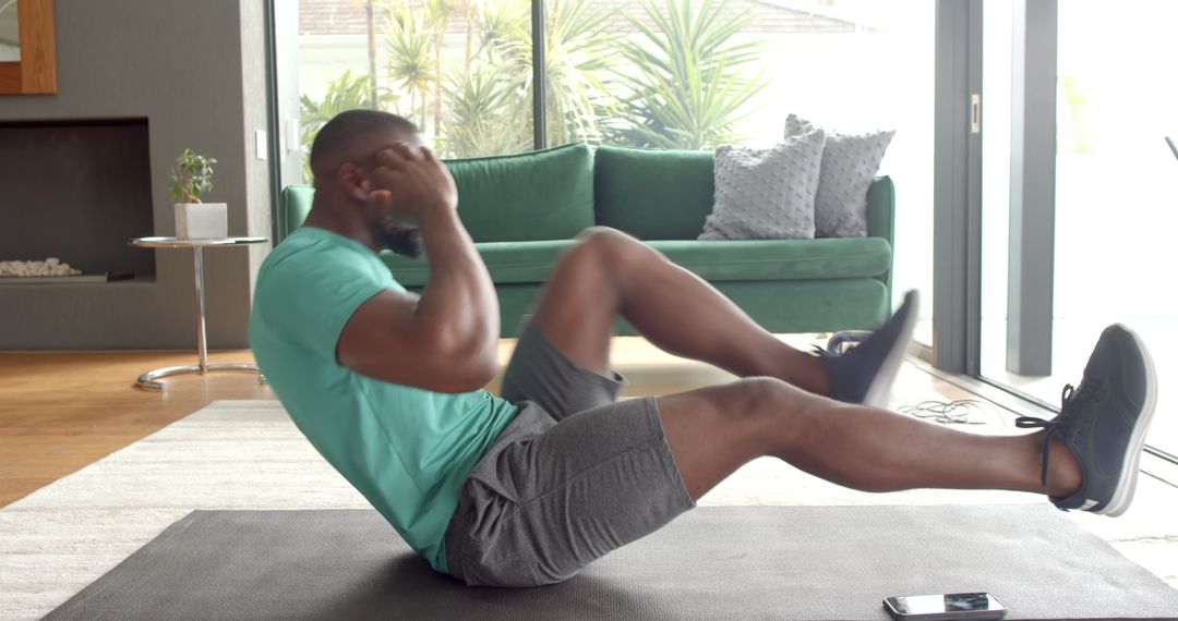 Man Performing Bicycle Crunch on Exercise Mat in Living Room