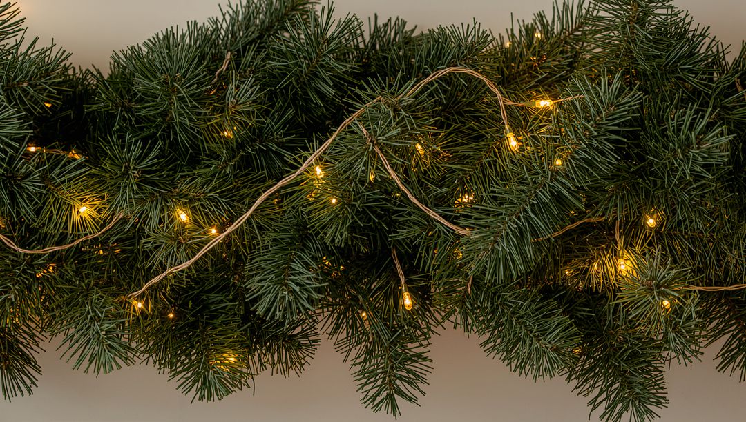 Glowing Evergreen Garland Running Along Mantel with Warm White String Lights