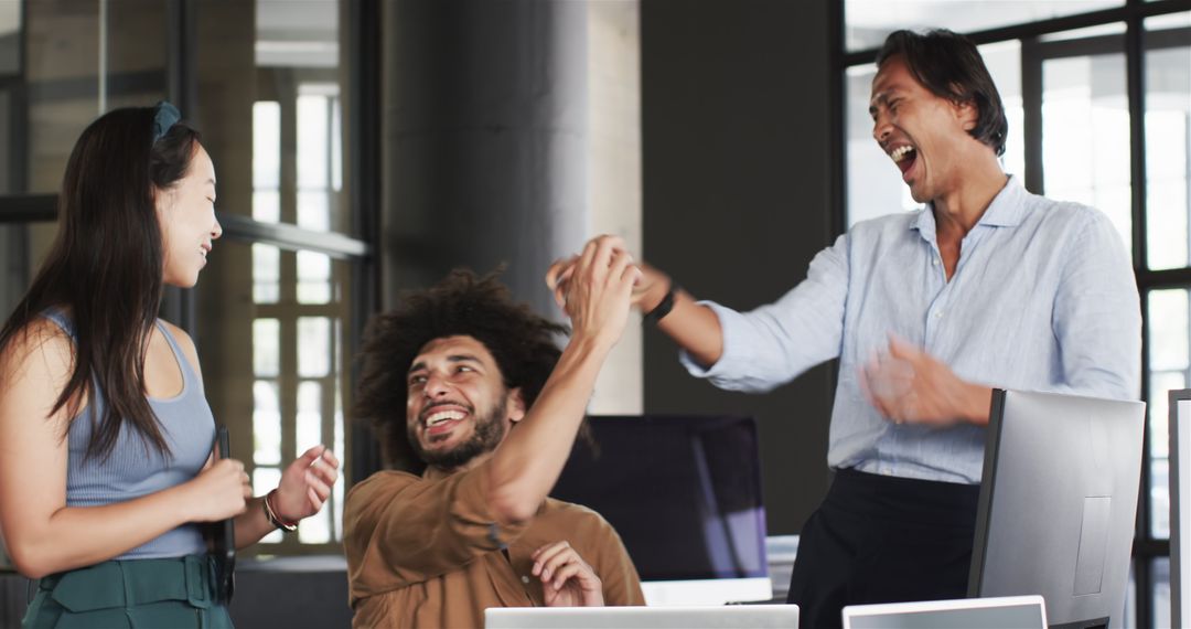 Diverse Team Celebrating Success Enthusiastically in Modern Office