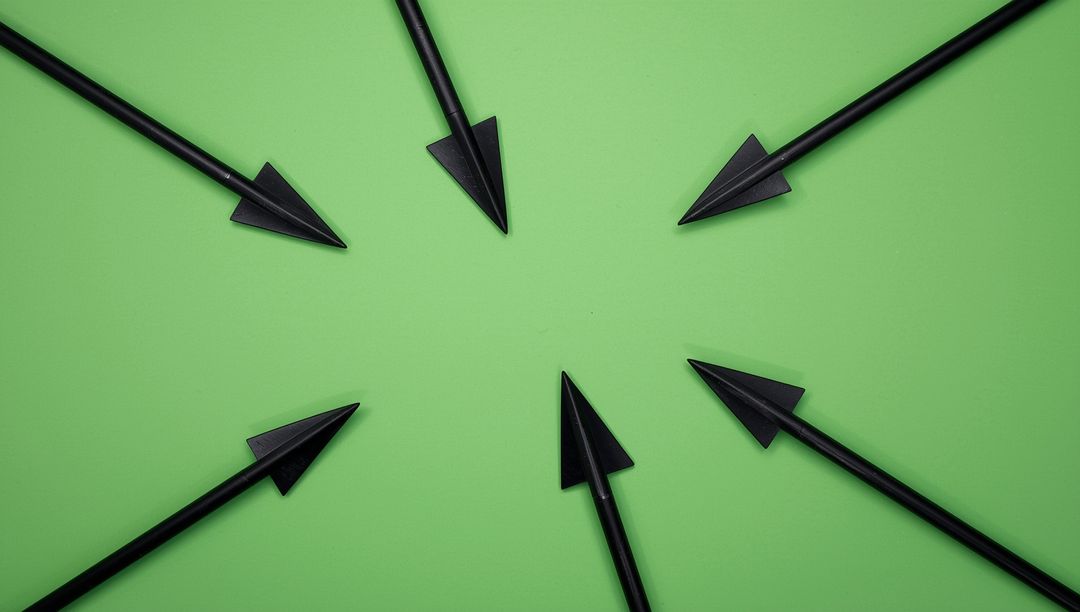 Black Arrows Pointing Inward on Green Background