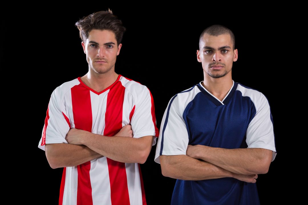 Two Football Players Standing with Arms Crossed Against Black Background - Free Images, Stock Photos and Pictures on Pikwizard.com