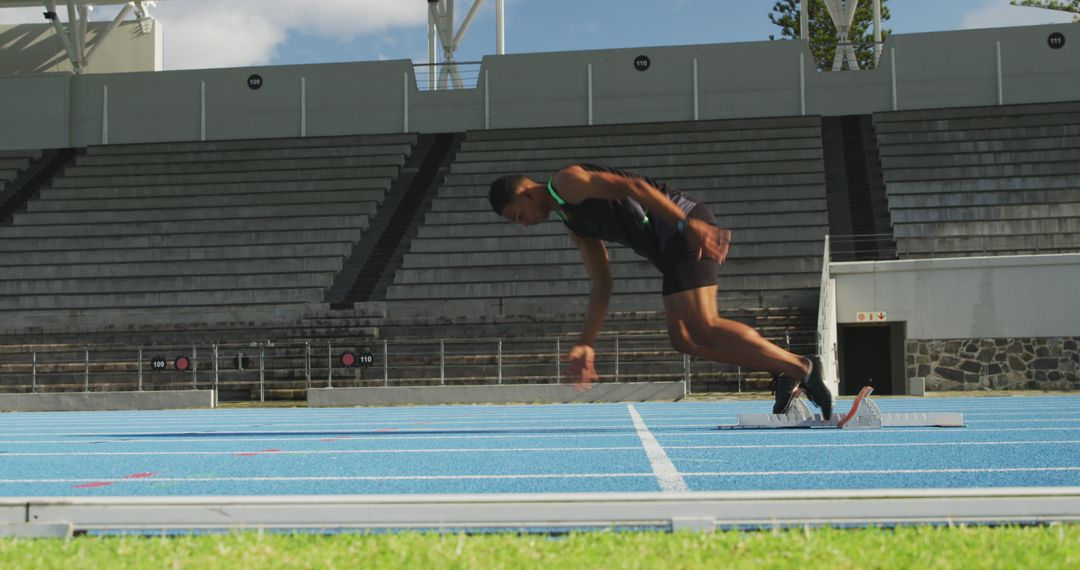 Athlete Starting Race on Blue Track in Outdoor Stadium - Free Images, Stock Photos and Pictures on Pikwizard.com