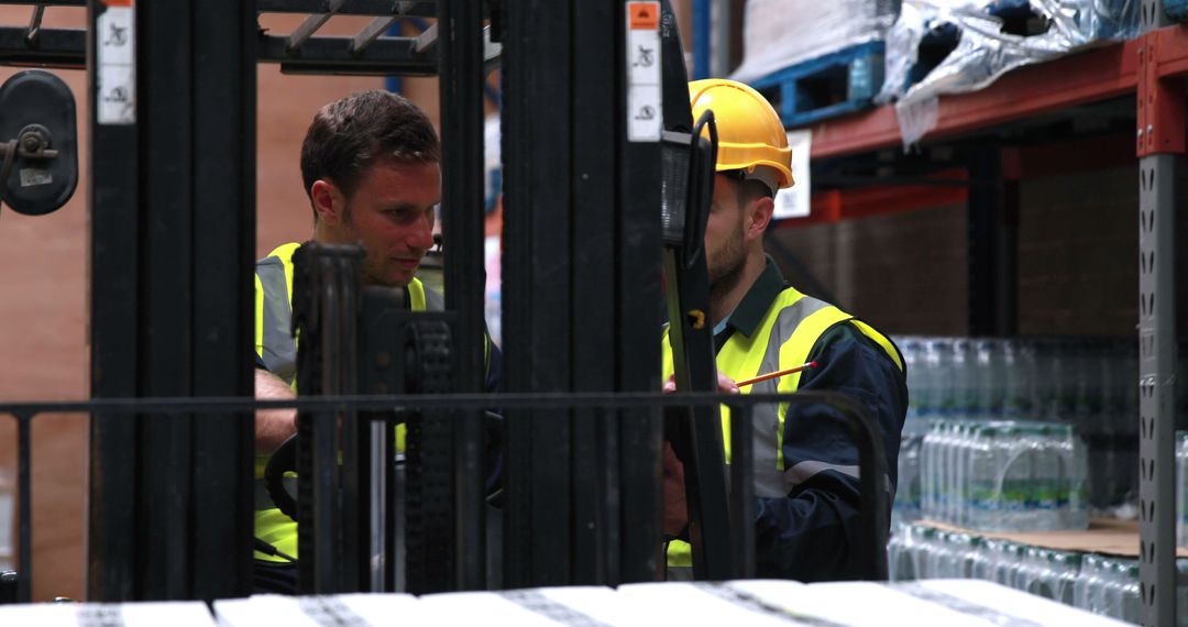 Warehouse Workers Operating Forklift in Distribution Center - Free Images, Stock Photos and Pictures on Pikwizard.com