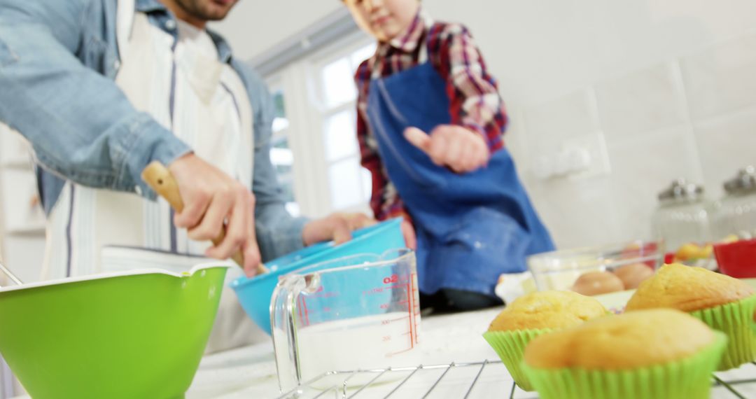 Father and son baking muffins together in kitchen - Free Images, Stock Photos and Pictures on Pikwizard.com