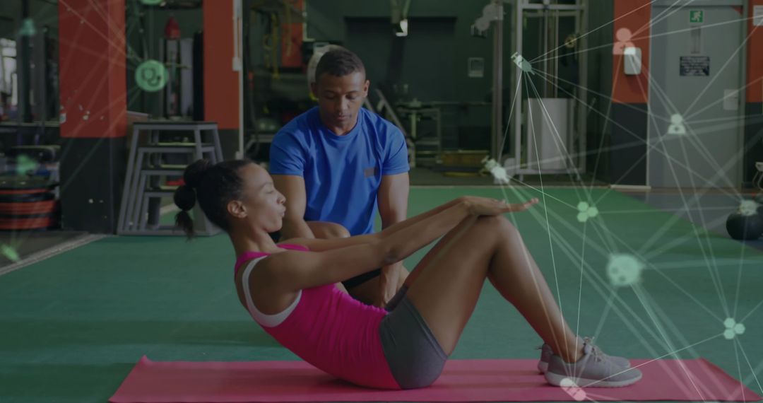 Personal Fitness Trainer Assisting Female Client with Abdominal Crunch Exercise