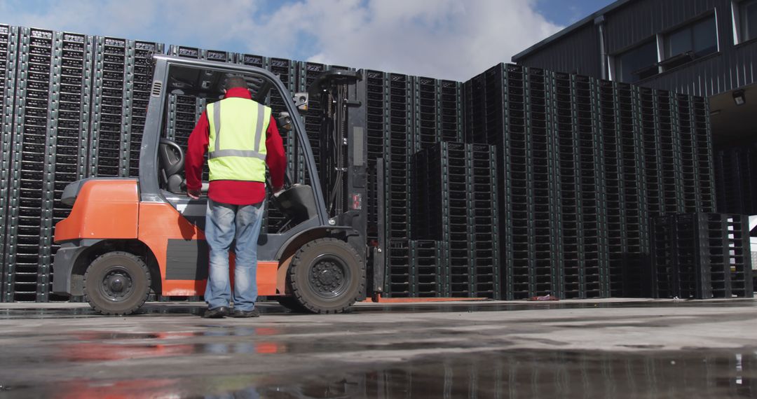 Worker Operating Forklift at Industrial Warehouse with Stacked Pallets - Free Images, Stock Photos and Pictures on Pikwizard.com