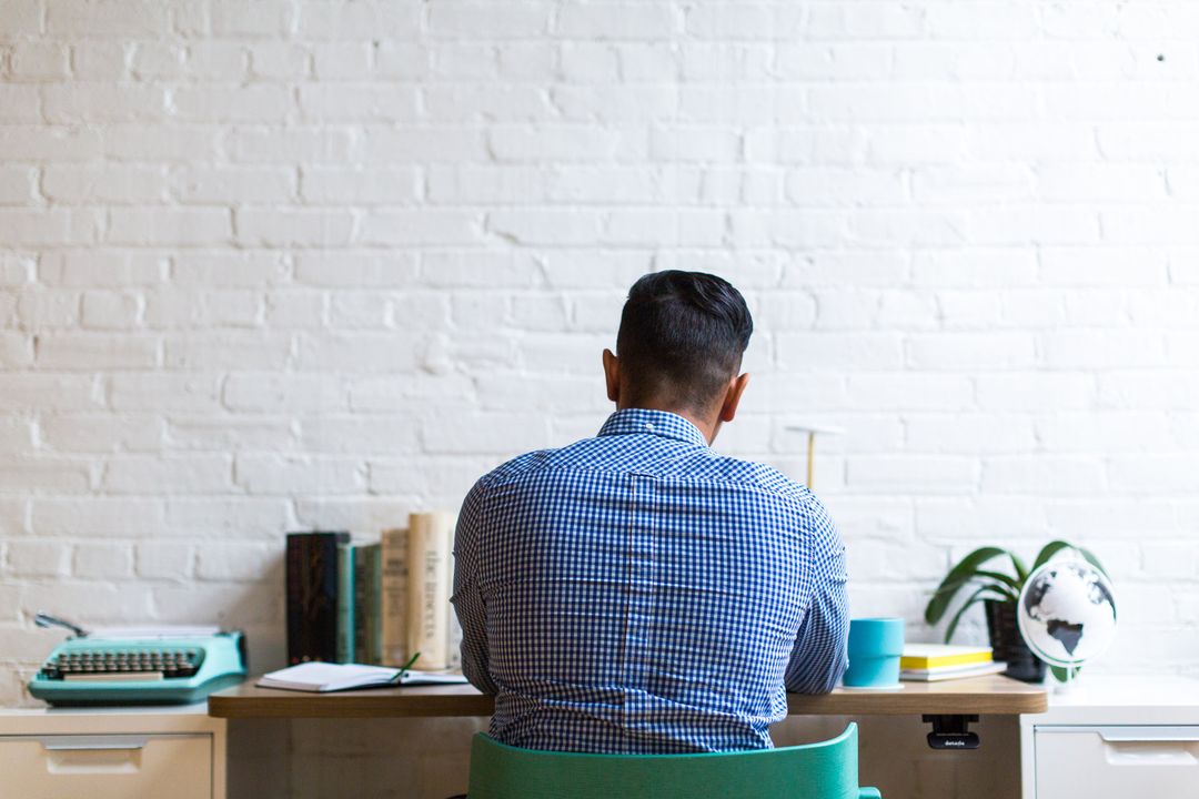 Man working at desk with books in modern home office