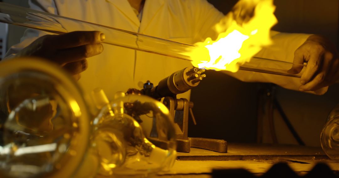 Glassblowing Artisan Carefully Heating Glass in Workshop