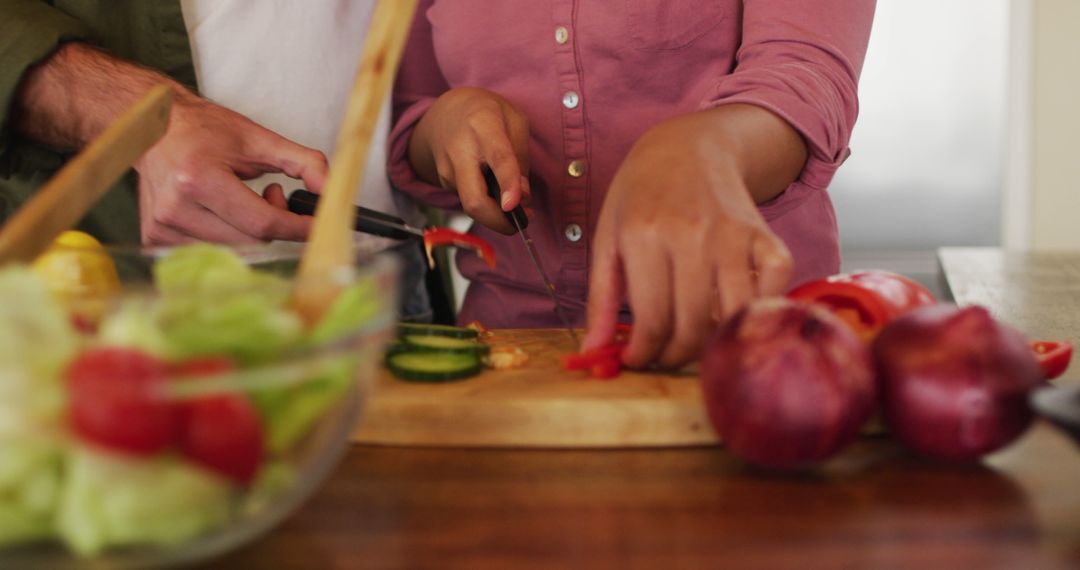 Couple Chopping Vegetables Together in Kitchen